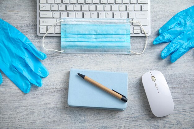 Photo medical mask gloves and computer keyboard on the table