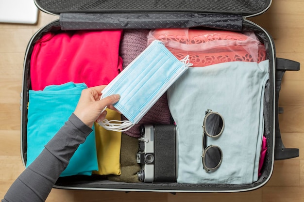 The medical mask is placed in the travel suitcase.