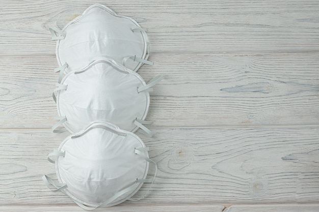 Medical mask isolation. Protection for respiratory tracts against viruses, influenza and coronavirus. Health care and surgical concept. wood background