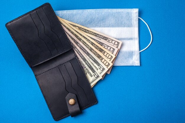 Photo medical mask and money. medical face shield on american money. financial crisis concept