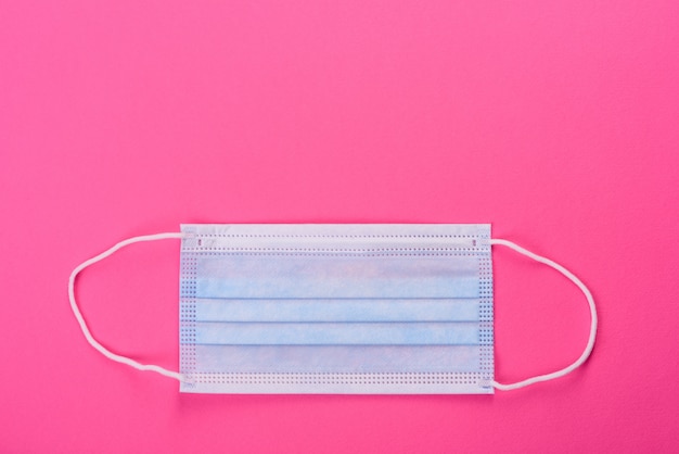 Medical mask on a pink table