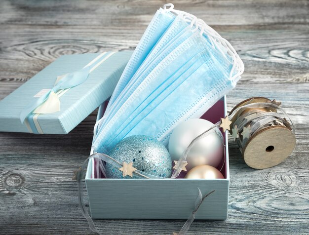 Medical masks and Christmas balls in an open box