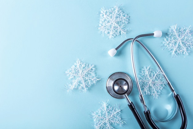 Medical New year composition with stethoscope and Christmas decoration, artificial snowflakes