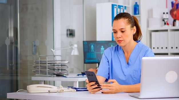 Infermiera medica che consulta il paziente online utilizzando lo smartphone, spiegando il trattamento per la malattia. consultazione remota del terapista nell'applicazione di chat mobile virtuale di teleconferenza, telemedicina, concetto di aiuto