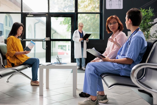 Medical nurse taking notes on papers at examination with old\
asian patient, doing checkup visit in hopsital waiting room.\
assistant writing report at appointment with woman. medicine\
support