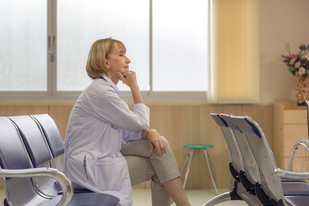 Photo in a medical office, a senior doctor poses for a portrait.