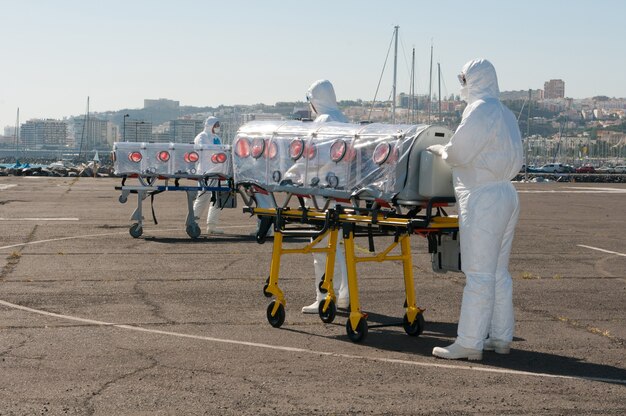 medical people with ambulance bed for ebola covid or pandemic