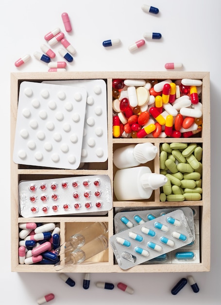 Medical pills and ampules in wooden box