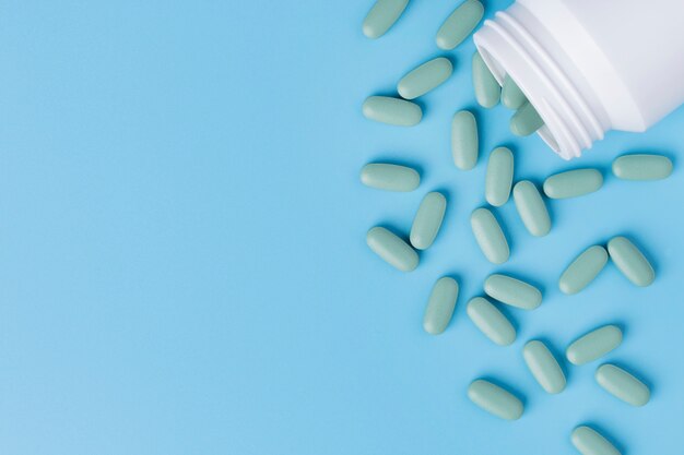 Medical pills on blue background.