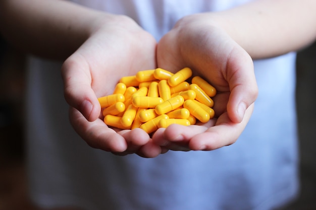 Medical pills in the hands of a child closeup