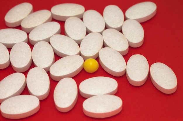 Medical pills on a red background macro shot, close-up view