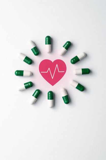 Medical pills on white background with copy space, and red heart icon