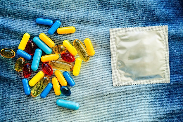 Medical potency pills and condom on jeans