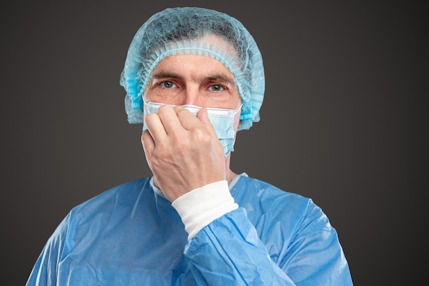 Medical practitioner adjusting mask during work