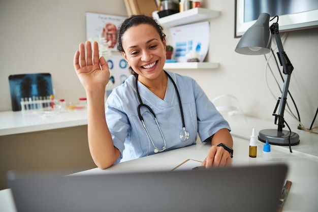 Medical practitioner waving to a computer display