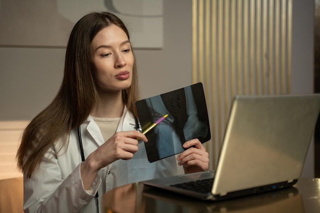 Photo a medical professional presumably a doctor is engaged in a virtual consultation she is holding a