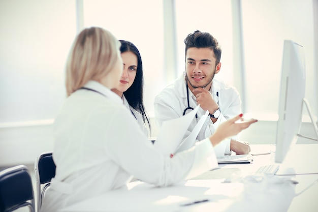 Medical professionals are discussing something sitting at the office Desk . the concept of health