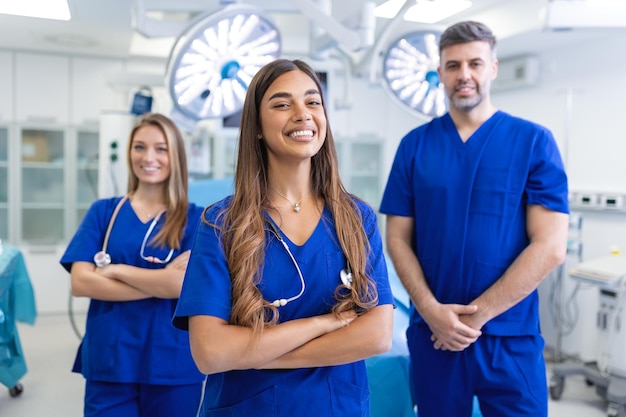 健康保護の概念を一緒に立っている医療専門家は、病院に立ちながらカメラを見て微笑んでいる医師の成功したチームです