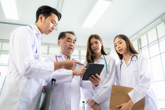 Photo a medical professor and medical student discuss a case study involving disease therapy for a hospital patient
