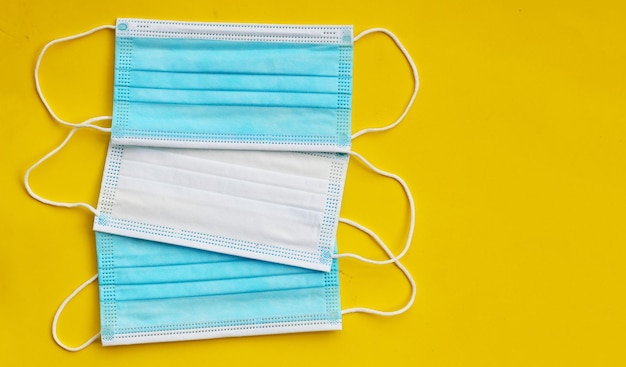 Medical protective masks on yellow background