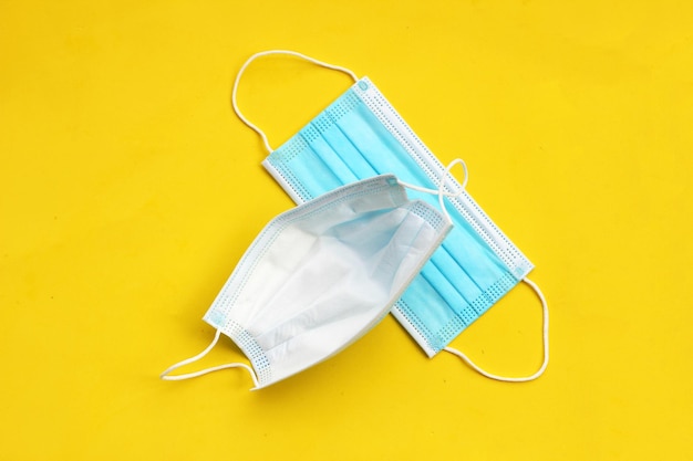 Medical protective masks on yellow background