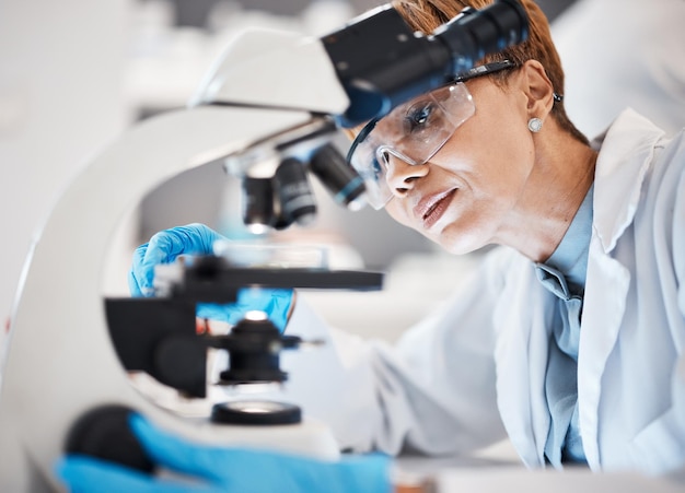 Photo medical science woman and microscope in a laboratory for research analytics and to study particle scientist person with glasses for dna or bacteria in lab for innovation future and biotechnology