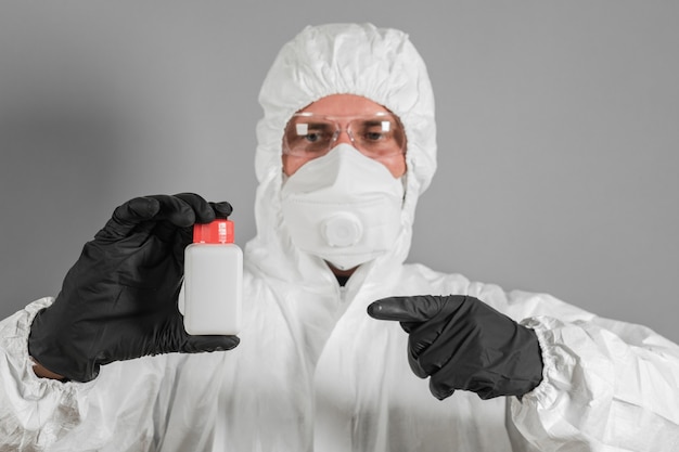 A medical scientist or a policeman wearing protective clothing holds a plastic tube in his hand. The concept of health and crime.