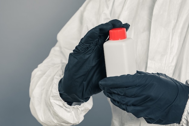 A medical scientist or a policeman wearing protective clothing holds a plastic tube in his hand. The concept of health and crime.