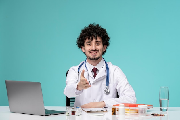 Medical serious cute handsome doctor working on computer in lab coat giving handshake