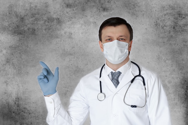 코로나바이러스에 대한 의료진 예방 장비. 마스크에 청진 기를 가진 남자 의사의 초상화입니다.