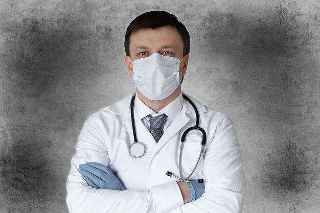 Medical staff preventive gear against coronavirus. Portrait of male doctor with stethoscope in mask.