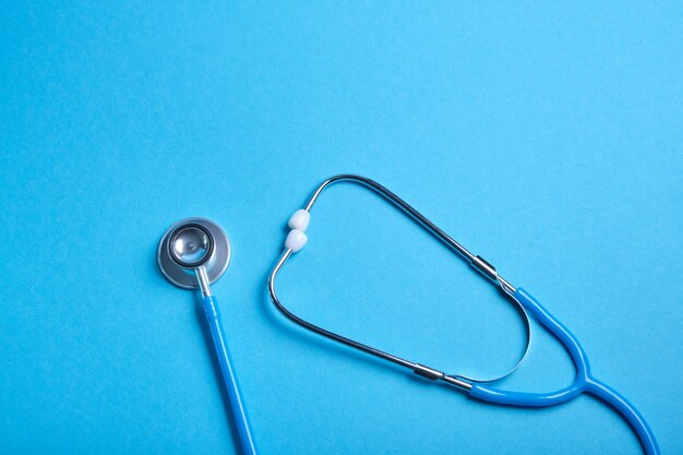 Medical stethoscope on blue surface