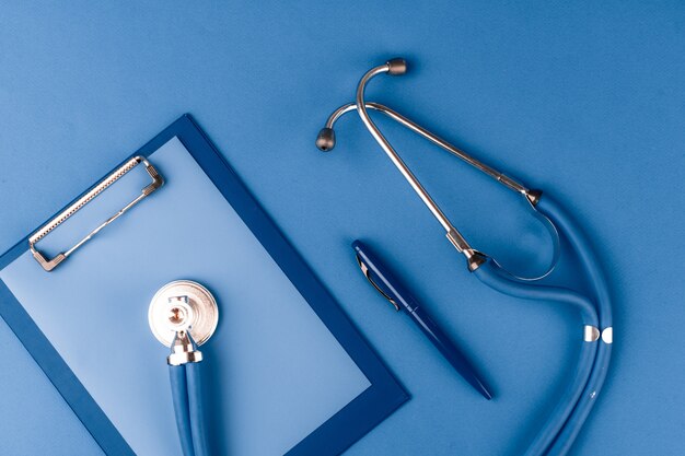 Medical stethoscope on classic blue table top view