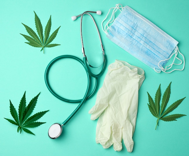Medical stethoscope, disposable mask, latex sterile gloves and green hemp leaf