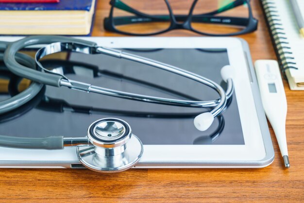 Photo medical stethoscope for doctor checkup with tablet computer on doctor table as medical concept