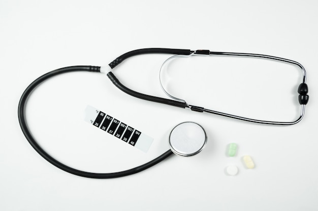 Medical stethoscope, medication and thermometer-strip on white isolated background