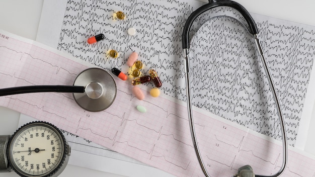 Medical stethoscope with tonometer and ecg on a light background. top view