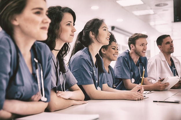 Foto studenti di medicina ascoltano seduti alla scrivania