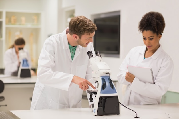 Medical students working with microscope