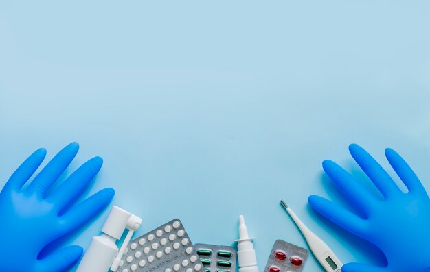 Medical supplies lie on a blue surface in the style of flat lay.