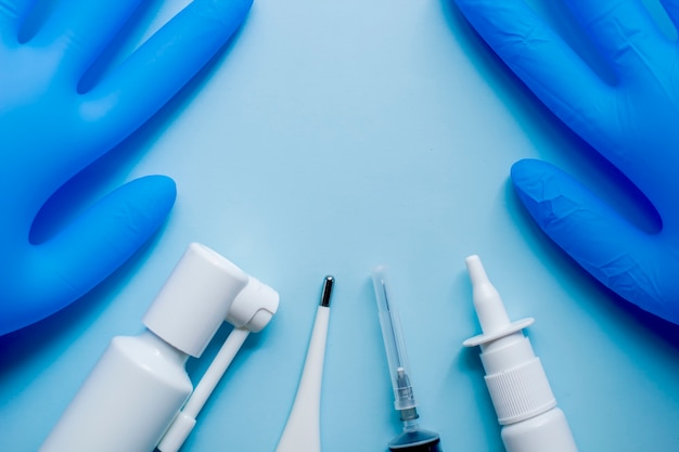 Medical supplies lie on a blue surface in the style of flat lay.