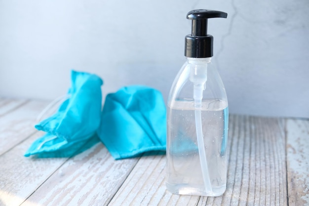 Medical surgical masks and hand sanitizer gel on table