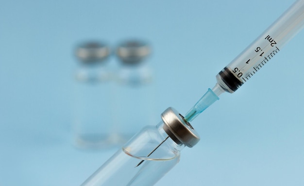 A medical syringe collects medicine from an ampoule