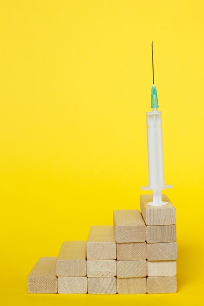 Medical syringe on a ladder made of wooden sticks