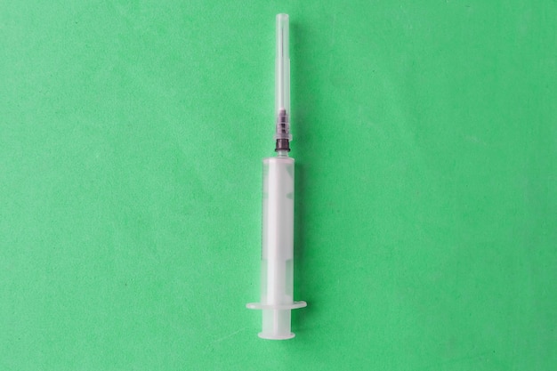 パステルブルーの背景に描かれた注射器トップビューは最小限