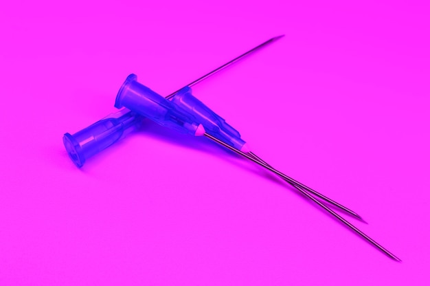 紫色の背景に医療用注射器の針のコンパイル。