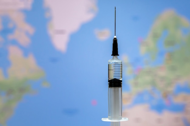 Medical syringe for a vaccine on World map