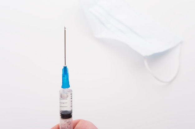 Photo medical syringe with a drop of solution at the end of the needle