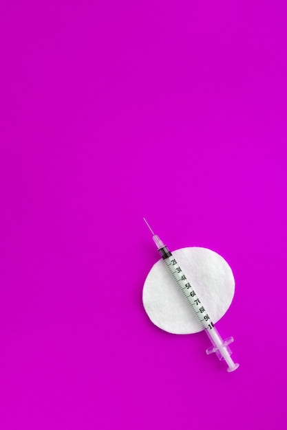 Medical syringes on pink background