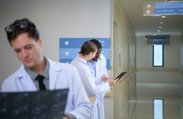 Medical teacher and interns analyzing the xray results of the patients brain before major surgery